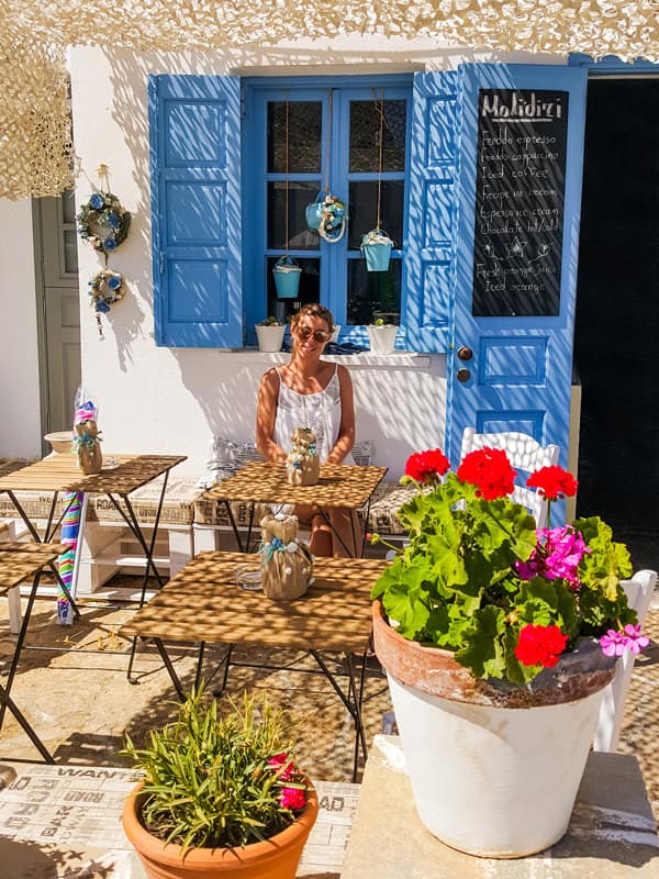 girl sitting at a cafe in folegandros greece