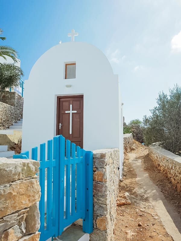 small church with a blue gate in folegandros greece